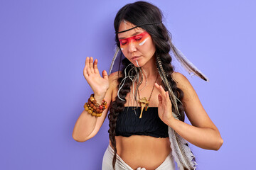 young pagan female is a shaman isolated in studio on purple background, people are different from...