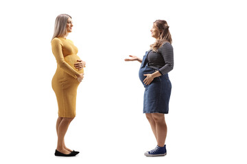 Pregnant woman in a yellow dress having a conversation with another pregnant woman