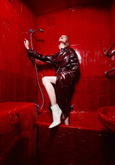 Girl model in a red coat in a bathroom with red walls.