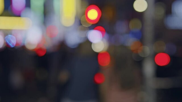 People at traffic lights, crowded Manhattan New York City street by night, unfocused
