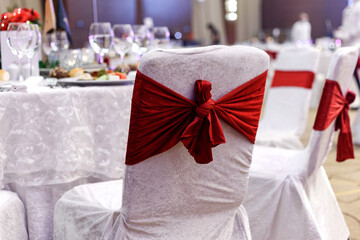 Festive round table setting in a prestigious restaurant for dinner. Banquet decoration with white and red