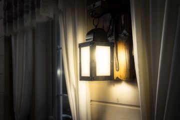Vintage wall lamp with shining on light bulb decorated in dark wooden house. Low key image. Interior design.