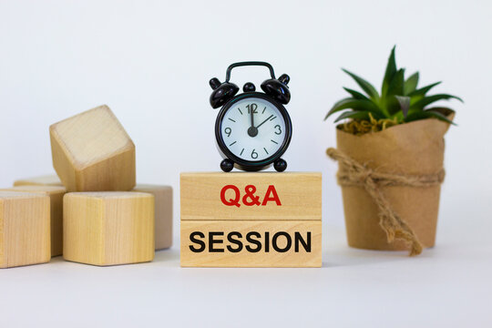 Q And A, Questions And Answers Session Symbol. Concept Words 'Q And A Session' On Wooden Blocks On A Beautiful White Background. Black Alarm Clock, House Plant. Business And Q And A Session Concept.