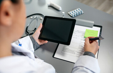 Unrecognizable female doctor using tablet while working