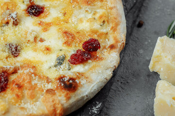 Hot four cheeses delicious rustic homemade american pizza with thick crust on black table