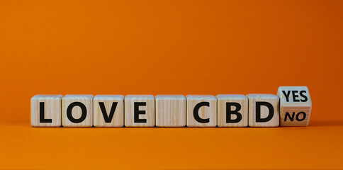 Love CBD, cannabidiol symbol. Turned a cube and changed words 'love CBD no' to 'Love CBD no'. Beautiful orange background, copy space. Medical and love CBD cannabidiol concept.