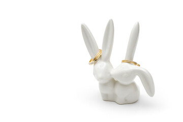 Cute ceramic bunnies ring holder on white with copy space