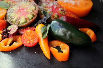 Salad of colorful vegetables on a black surface selective focus.