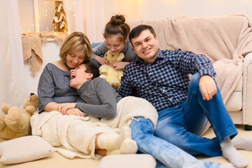 portrait of a family sitting on a sofa at home, four people having fun together