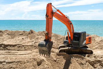 Close up details of industrial excavator working on construction site and sea background