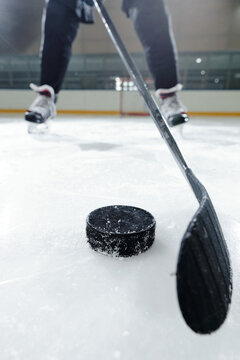 Legs Of Male Hockey Player In Sports Uniform And Skates Going To Shoot Puck