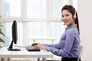 A Business woman with headset using computer