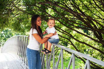 young pretty brunette mother with little cute boy walking in park happy smiling, lifestyle people concept