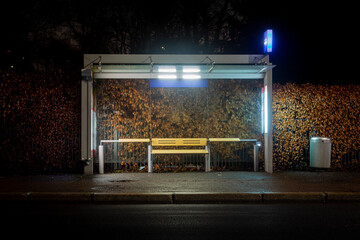 Modern bus stop illuminated at night. © Seanid