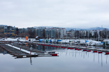 Modern buildings near the snowy embankment and the yacht port.