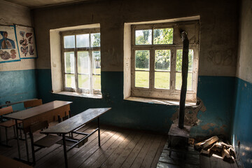 Old and abandoned school classroom interior, in black and white.