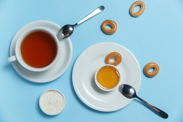 Obraz na płótnie Canvas cup with tea, honey and bagels on a blue background