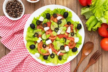 National Greek salad with seasonings and spices on a wooden background.