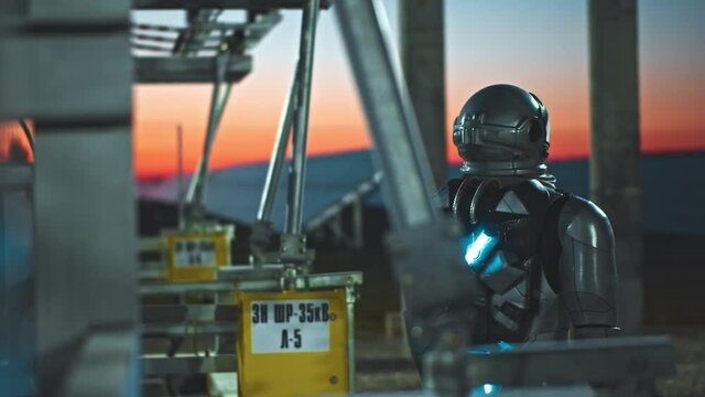Space man. Evening view at the astronaut walking on between photovoltaic power units while examining ecological technologies. Man working at sun energy farm. Renewable energy. Sustainable production
