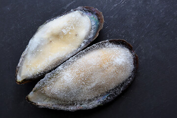 Fototapeta na wymiar Greenshell mussels frozen on black background. Frozen mussels