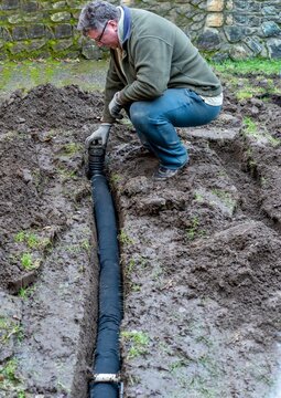 Drainage line placed in soggy muddy lawn to reduce wetness