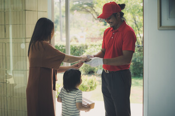 Home delivery service , Asian deliver man  in green uniform delivering fresh vegetables and Food ingredients to customer at home.