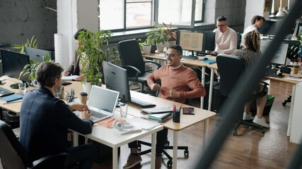 Happy Arab businessman is enjoying good news in office doing high-five with colleagues while people are applauding congratulating lucky coworker - Powered by Adobe