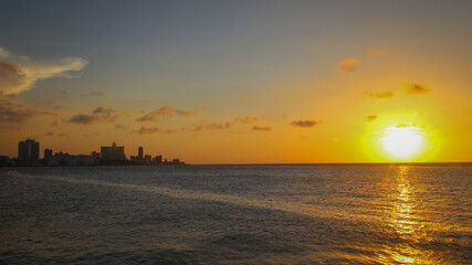 Fototapeta premium Havana, Cuba skyline next to a beautiful sunset over the ocean.