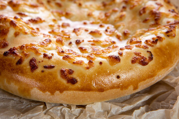Khachapuri freshly prepared on a wooden tray close up