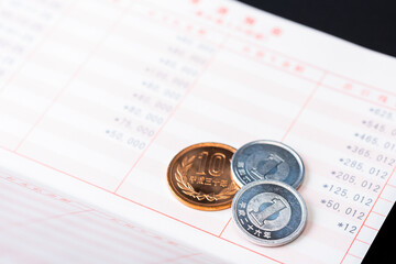 貯金残高が底をつくイメージ（預金通帳と小銭）