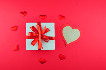Gift box in a craft paper package with a red ribbon and blank for love letter. Valentine's day greeting card.
