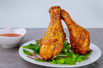 Grilled chicken drumsticks marinated with buffalo sauce.