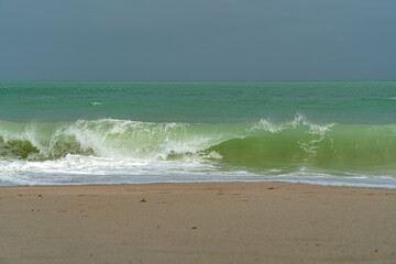 Big waves and surf on a sandy tropical beach