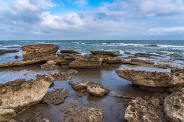 Fototapeta na wymiar Wave splashing at the rocks, freshness on beach