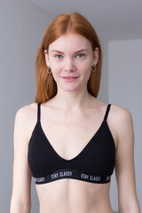 Obraz premium snap shot of pretty model in black lingerie on white background with red hair 