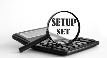 Focused on Setup Set concept. Magnifier glass with text on calculator. Business concept