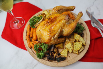 Roasted chicken served on the wood tray with baby carrots, roasted potatoes and mushrooms