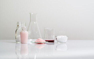 Beauty care cream, Pink flake chemicals, Potassium Permanganate Liquid, Cetyl esters wax and Erlenmeyer flask on white laboratory table.