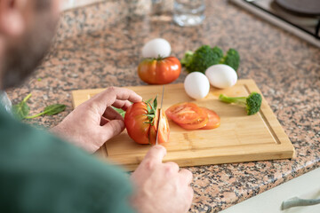 Man preparing delicious and healthy breakfast at home kitchen