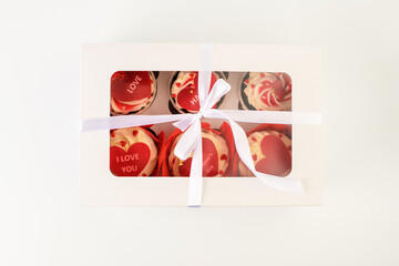 .Cupcakes in a box. Cupcakes in the shape of a heart in a box with different labels, set on a white background. Valentine's Day