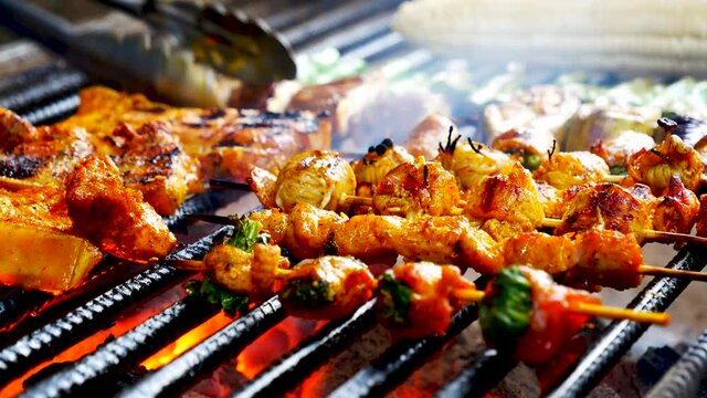 BBQ Barbecue grilled meat stick on fire flame with hot charcoal cooking outside. beef grilling picnic meal outdoor with smoke bacon spicy sausage for party 