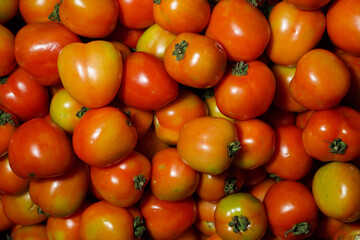 Fototapeta na wymiar Delicious red tomatoes it can be used as background. (selective focus). Tomato vegetable concept space for banner top view. Tomatoes for background. Healthy eyes with regular consumption of tomatoes.
