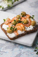Prawns toast with a micro-green, olives on  wooden background,  concept of healthy eating,  assortment of bruschetta