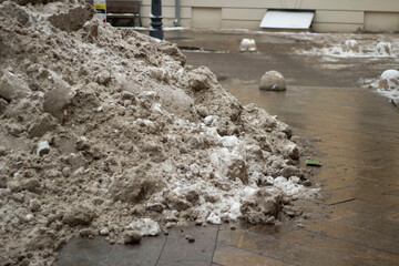 A pile of snow on the road. Snow removal. Snow drift. The work of municipal services to clean the street from snow.