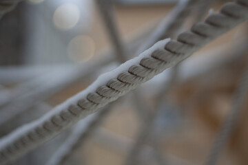 The ropes are stretched in different directions. Rope texture. Snow covered belay ropes. Tightly...