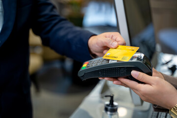 Close up of card payment being made between customer to receptionist at restaurant.