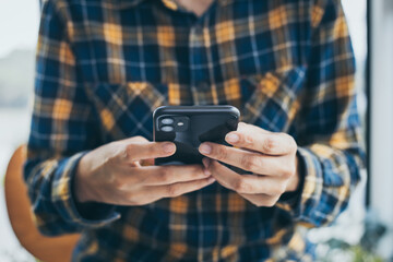 man work using cell phone hand holding mobile texting message contact us.chatting,search internet...
