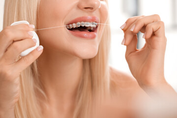 Young woman with dental braces and floss, closeup