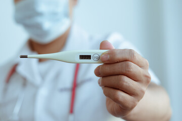 Medical thermometer in palm, hand of a doctor or nurse.