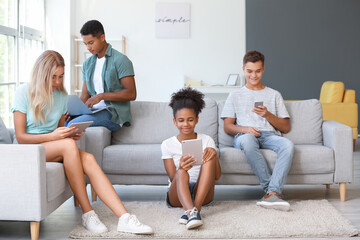 Teenagers with different devices at home